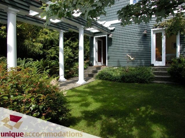 Spacious front porch with columns and lush greenery, perfect for relaxation. - 3586 Creery Ave, West Vancouver