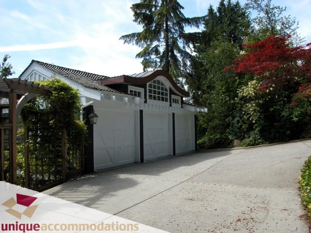 Spacious 7-bedroom house with a charming white exterior and lush greenery, perfect for a family or group. - 3586 Creery Ave, West Vancouver