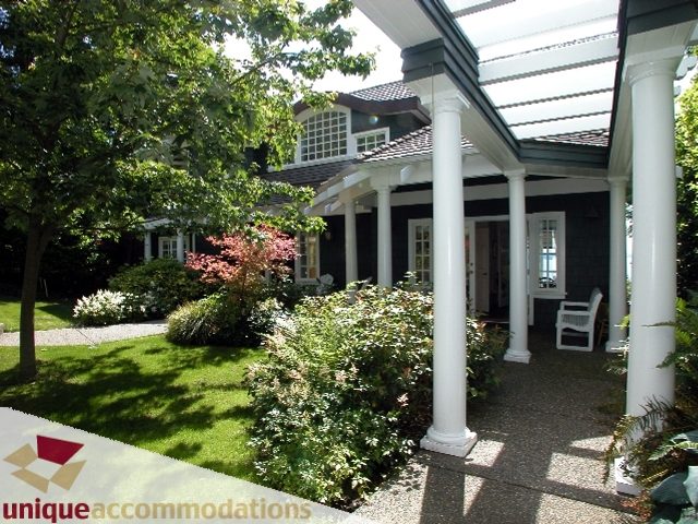 Spacious patio with white columns and lush greenery, perfect for relaxation. - 3586 Creery Ave, West Vancouver