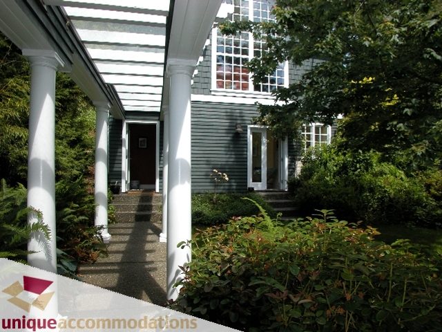 Spacious porch with white columns and lush greenery surrounding the entrance. - 3586 Creery Ave, West Vancouver