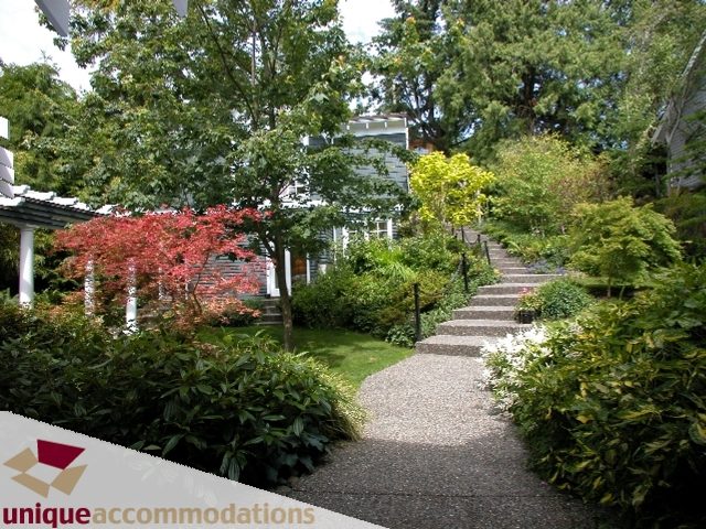 Spacious garden with stone pathway and vibrant foliage, perfect for relaxation. - 3586 Creery Ave, West Vancouver