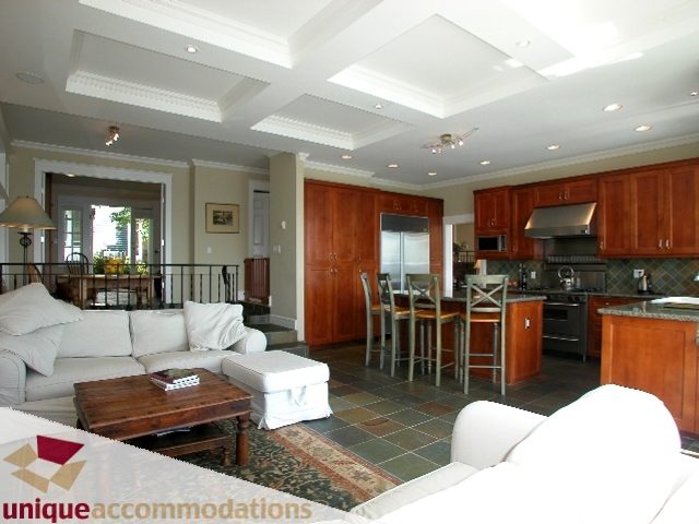 Open-concept living and kitchen area with granite countertops and tiled floors. - 3586 Creery Ave, West Vancouver