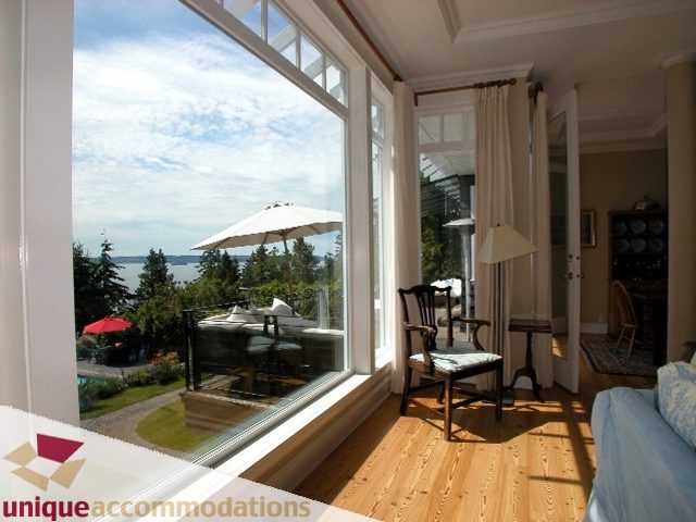 Spacious living room with hardwood floors, large windows, and a stunning city view. - 3586 Creery Ave, West Vancouver