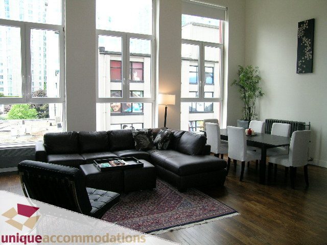 Bright living room with hardwood floors, city view, and modern furniture. - PH2 - 869 Beatty Street, Vancouver Downtown