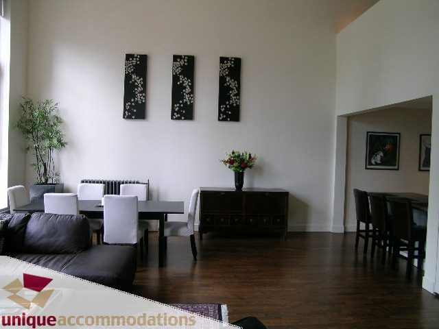 Furnished living room with hardwood floors, modern decor, and a cozy ambiance. - PH2 - 869 Beatty Street, Vancouver Downtown