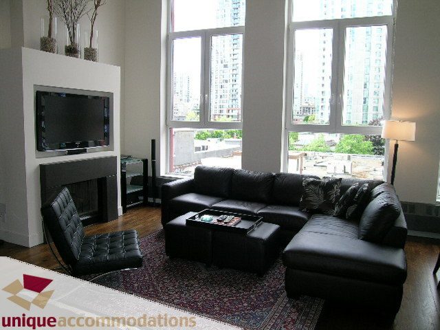 Bright living room with large windows, city view, and modern furniture. - PH2 - 869 Beatty Street, Vancouver Downtown
