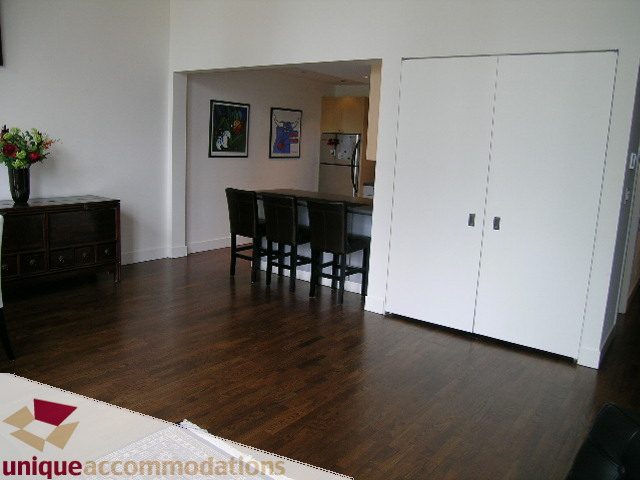 Bright kitchen with dark hardwood floors, open dining area, and modern decor. - PH2 - 869 Beatty Street, Vancouver Downtown