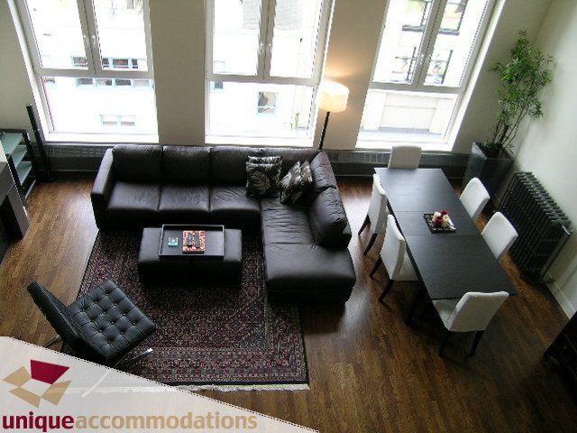 Bright living room with hardwood floors, modern furniture, and large windows. - PH2 - 869 Beatty Street, Vancouver Downtown