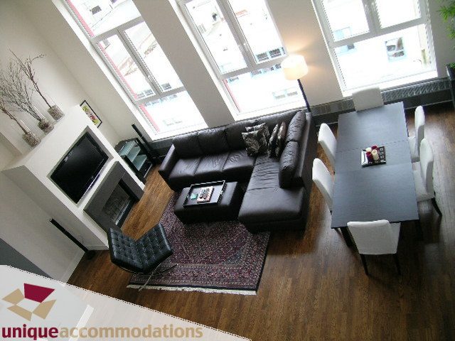 Bright and airy living room with hardwood floors, large windows, and a cozy sectional sofa. - PH2 - 869 Beatty Street, Vancouver Downtown