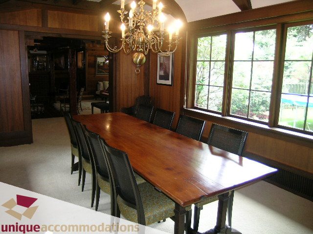 Dining area with wooden table, chairs, chandelier, and large windows. - 419 Inglewood ave, West Vancouver