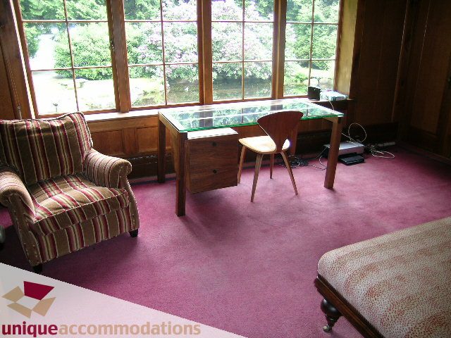 Bright living room with large windows, wooden furniture, and a glass-top desk. - 419 Inglewood ave, West Vancouver