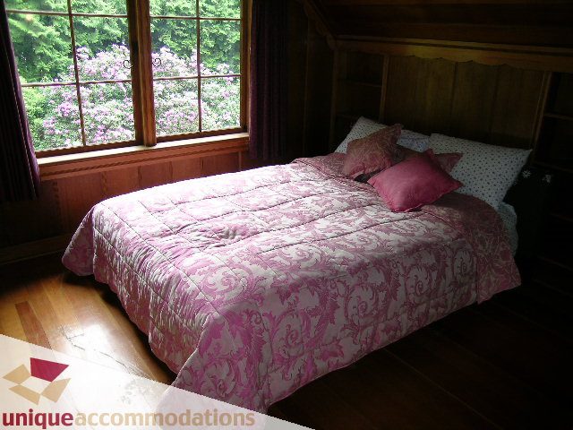 Spacious bedroom with wooden floors, large windows, and pink damask bedding. - 419 Inglewood ave, West Vancouver