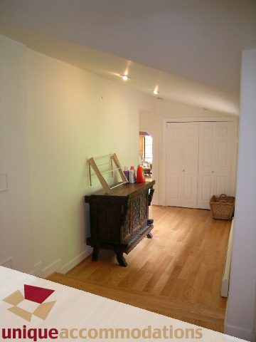 Bright living room with hardwood floors and a white door leading to another room. - 419 Inglewood ave, West Vancouver
