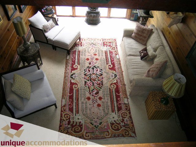 Bright living room with patterned rug, white furniture, and wooden accents. - 419 Inglewood ave, West Vancouver