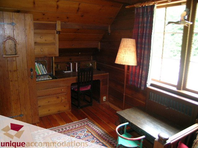 Bright bedroom with wooden furniture, hardwood floors, and a plaid curtain. - 419 Inglewood ave, West Vancouver