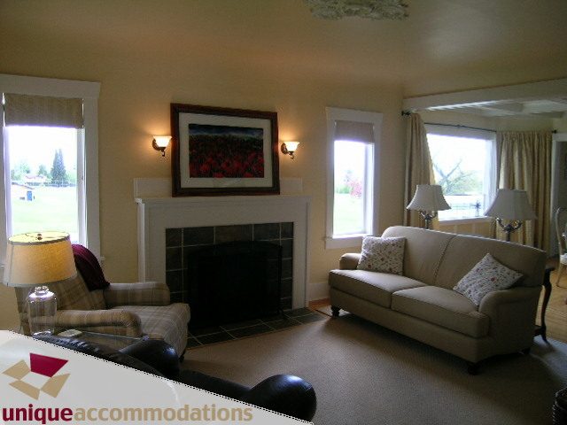 Spacious living room with large windows, cozy furniture, and a fireplace. - 1505 Grand Blvd., North Vancouver