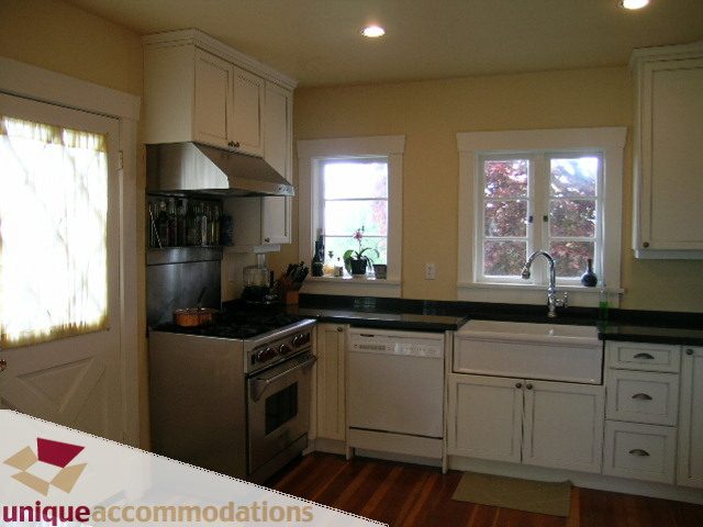 Bright kitchen with white cabinets, stainless steel appliances, and hardwood floors. - 1505 Grand Blvd., North Vancouver
