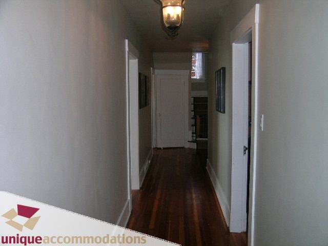 Furnished hallway with hardwood floors and white walls. - 1505 Grand Blvd., North Vancouver