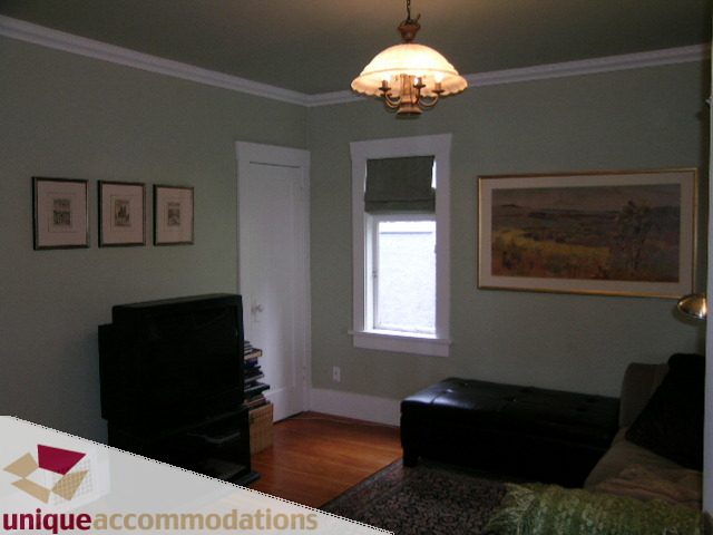 Living room with hardwood floors, framed artwork, and a chandelier. - 1505 Grand Blvd., North Vancouver