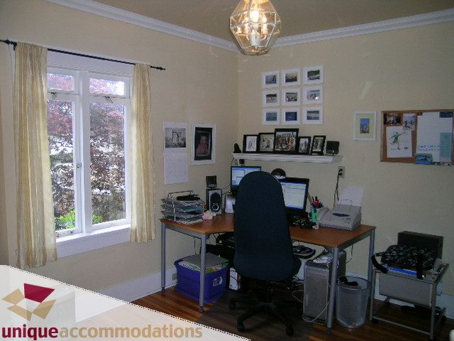 Furnished office with hardwood floors, desk, computer, and framed pictures on wall. - 1505 Grand Blvd., North Vancouver
