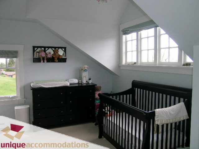 Bright attic bedroom with two cribs, large window, and dresser. - 1505 Grand Blvd., North Vancouver