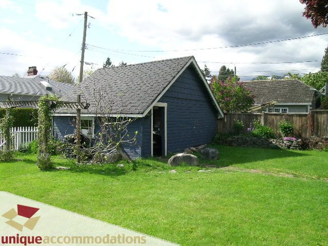 Furnished living room with cozy corner fireplace and green lawn. - 1505 Grand Blvd., North Vancouver