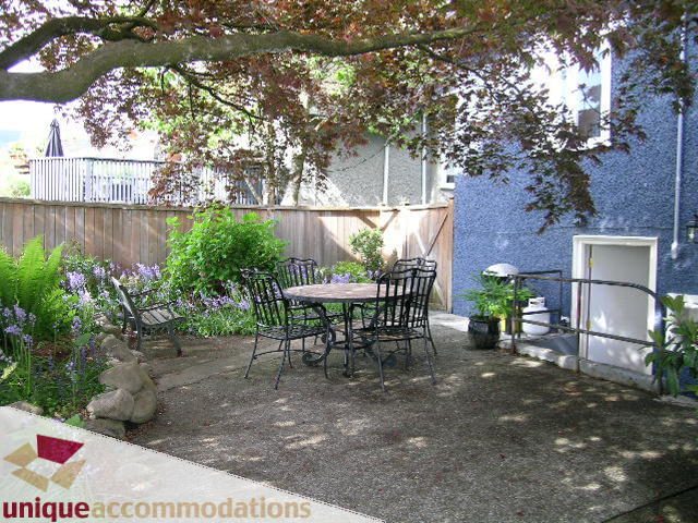 Furnished patio with outdoor furniture, greenery, and a wooden fence. - 1505 Grand Blvd., North Vancouver