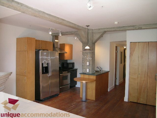 Bright kitchen with stainless steel appliances and hardwood floors. - 512-1216 Homer Street, Vancouver Downtown