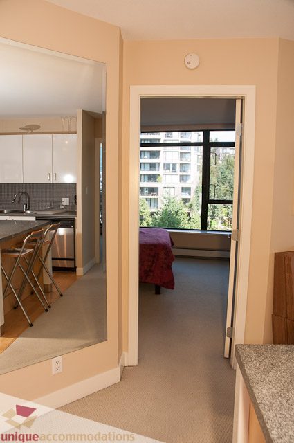Bright living room with city view and modern kitchen in the background. - 508-155 West 1st Street, North Vancouver