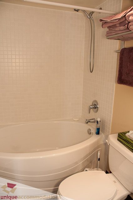 Furnished bathroom with white tile and a bathtub. - 508-155 West 1st Street, North Vancouver