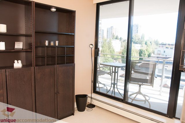 Furnished living room with dark wood shelving and city view. - 508-155 West 1st Street, North Vancouver