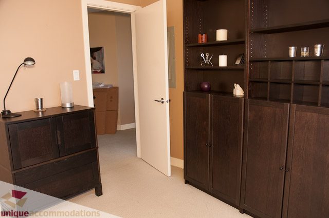 Furnished living room with dark wood shelving and a desk lamp. - 508-155 West 1st Street, North Vancouver