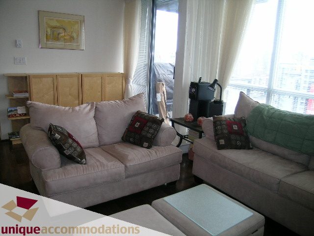 Furnished living room with a large window, city view, and cozy seating area. - 2001-1199 Seymour Street, Vancouver Downtown