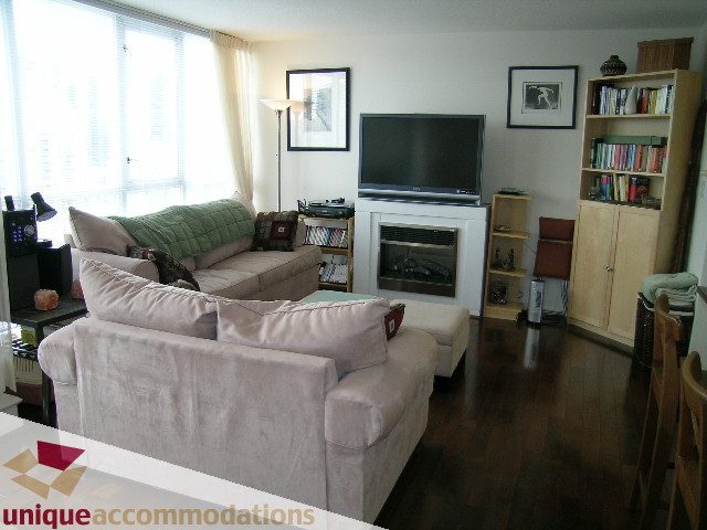 Bright living room with plush sofa, hardwood floors, and city view. - 2001-1199 Seymour Street, Vancouver Downtown