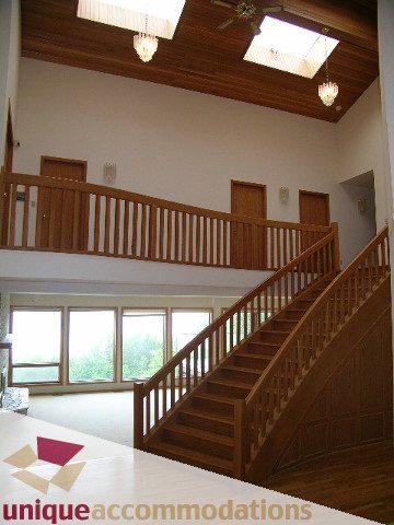 Furnished living room with hardwood floors and a staircase leading to upper level. - 1472 Camridge Road, West Vancouver
