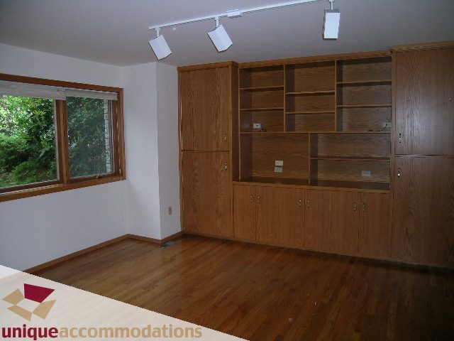 Bright living room with wooden floors and built-in shelving. - 1472 Camridge Road, West Vancouver