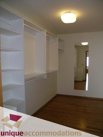 Spacious walk-in closet with built-in shelves and hardwood floors. - 1472 Camridge Road, West Vancouver