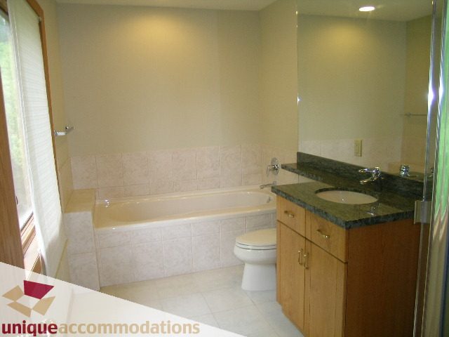 Spacious bathroom with granite countertops and wooden cabinets. - 1472 Camridge Road, West Vancouver