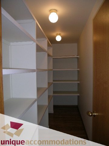Spacious walk-in closet with built-in shelves and wooden door. - 1472 Camridge Road, West Vancouver