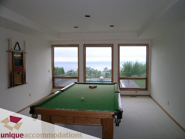 Bright game room with pool table, large windows, and scenic view. - 1472 Camridge Road, West Vancouver