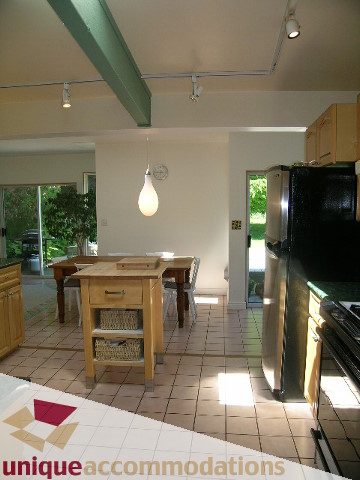 Bright kitchen with wooden cabinets, granite countertops, and a view of the garden. - 2556 Belloc Street, North Vancouver