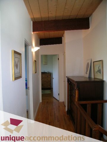 Furnished hallway with hardwood floors and wooden beams. - 2556 Belloc Street, North Vancouver