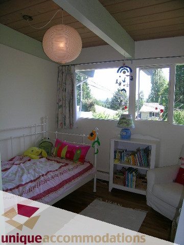 Bright sunroom with large windows, wooden ceiling, and cozy seating area. - 2556 Belloc Street, North Vancouver