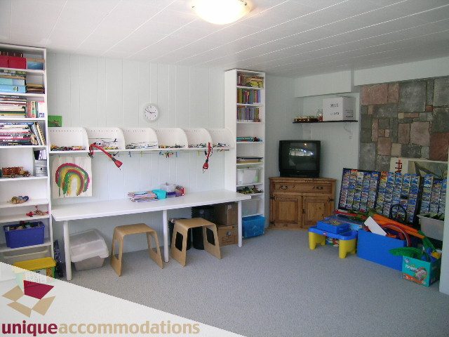 Bright playroom with shelves, toys, and a TV, perfect for kids. - 2556 Belloc Street, North Vancouver