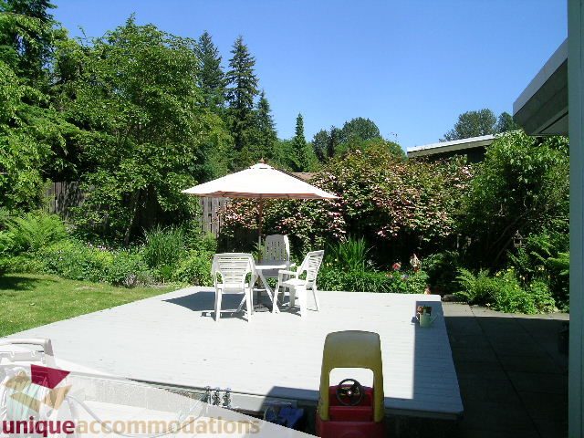Furnished patio with outdoor seating, umbrella, and garden view. - 2556 Belloc Street, North Vancouver