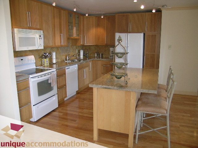 Bright kitchen with granite countertops, hardwood floors, and a central island. - 607 - 1490 Pennyfarthing Drive, Vancouver West Side