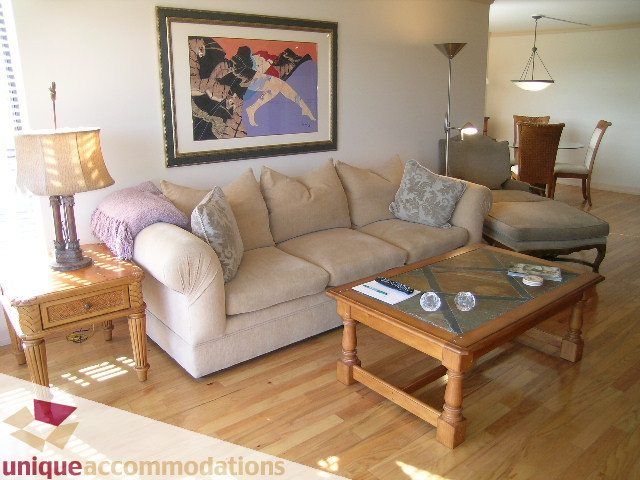 Furnished living room with hardwood floors, beige sofa, and modern decor. - 607 - 1490 Pennyfarthing Drive, Vancouver West Side