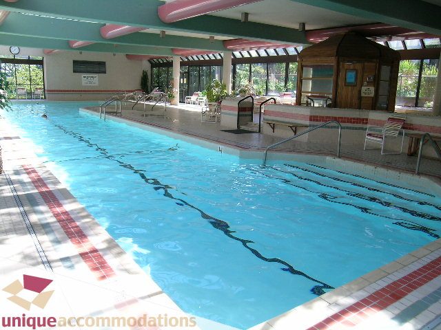 Spacious indoor pool with tiled edges and lounge seating. - 607 - 1490 Pennyfarthing Drive, Vancouver West Side