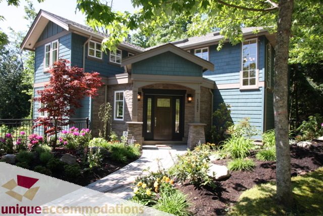 Furnished 3-bedroom house with blue siding, stone accents, and lush garden. - 1287 Sinclair Court, West Vancouver
