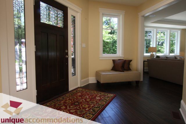 Bright living room with hardwood floors, large windows, and a cozy corner seating area. - 1287 Sinclair Court, West Vancouver